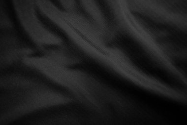 Arkaplan dokusu siyah kumaş. Soyut koyu dalgalı yumuşak. Kumaş kırışmış. Lüks moda tarzı..