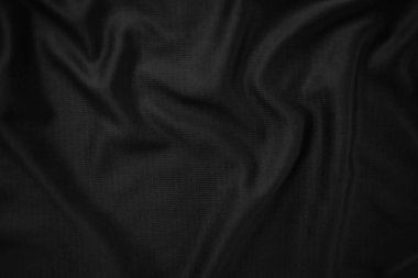 Arkaplan dokusu siyah kumaş. Soyut koyu dalgalı yumuşak. Kumaş kırışmış. Lüks moda tarzı..