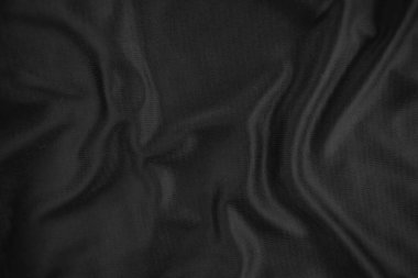 Arkaplan dokusu siyah kumaş. Soyut koyu dalgalı yumuşak. Kumaş kırışmış. Lüks moda tarzı..