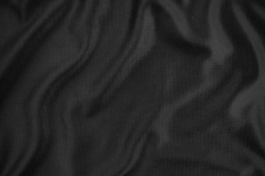 Arkaplan dokusu siyah kumaş. Soyut koyu dalgalı yumuşak. Kumaş kırışmış. Lüks moda tarzı..