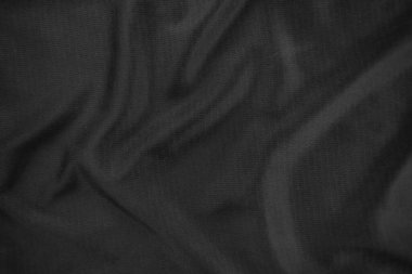 Arkaplan dokusu siyah kumaş. Soyut koyu dalgalı yumuşak. Kumaş kırışmış. Lüks moda tarzı..