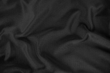 Arkaplan dokusu siyah kumaş. Soyut koyu dalgalı yumuşak. Kumaş kırışmış. Lüks moda tarzı..