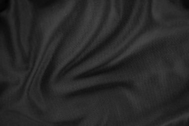Arkaplan dokusu siyah kumaş. Soyut koyu dalgalı yumuşak. Kumaş kırışmış. Lüks moda tarzı..