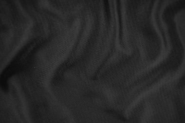 Arkaplan dokusu siyah kumaş. Soyut koyu dalgalı yumuşak. Kumaş kırışmış. Lüks moda tarzı..