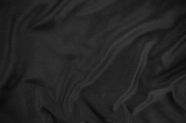 Arkaplan dokusu siyah kumaş. Soyut koyu dalgalı yumuşak. Kumaş kırışmış. Lüks moda tarzı..