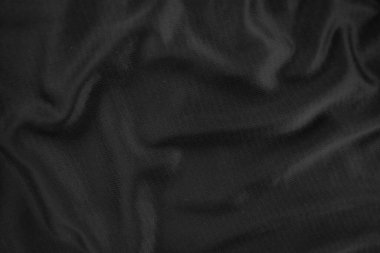 Arkaplan dokusu siyah kumaş. Soyut koyu dalgalı yumuşak. Kumaş kırışmış. Lüks moda tarzı..