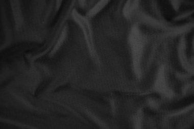 Arkaplan dokusu siyah kumaş. Soyut koyu dalgalı yumuşak. Kumaş kırışmış. Lüks moda tarzı..