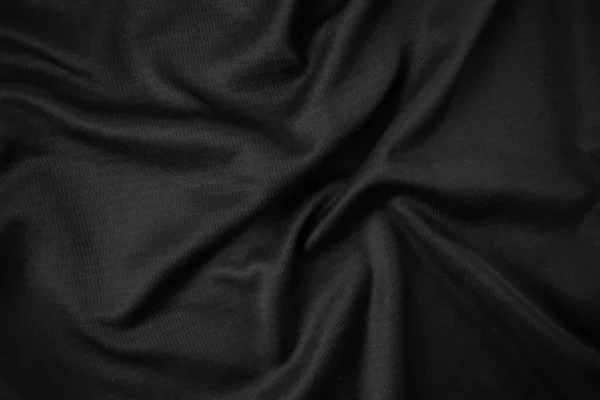 Arkaplan dokusu siyah kumaş. Soyut koyu dalgalı yumuşak. Kumaş kırışmış. Lüks moda tarzı..