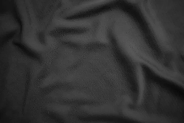 Arkaplan dokusu siyah kumaş. Soyut koyu dalgalı yumuşak. Kumaş kırışmış. Lüks moda tarzı..