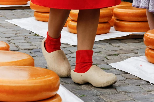 Genç kadın bacakları ahşap Hollandalı klomp Ayakkabı eski kasaba peynir piyasada Gouda, Hollanda