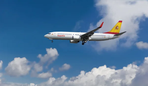 Kuyruk üzerinde İspanyol bayrağı ile özel ticari yolcu uçağı. Arka plan mavi bulutlu gökyüzü