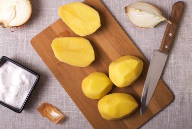 Ahşap bir kadın ve keten battaniyede patates ve soğan. Geleneksel yemek için gerekli malzemeler. Vejetaryen yemeği