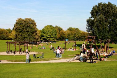 Birçok insan yazın karantinasız ve mesafeli bir şekilde parkta dinlenir.