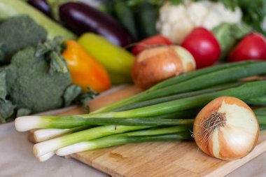 Taze taze yeşil ve arkaplanda güzel, bulanık sebzelerden oluşan soğanlar.