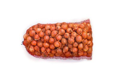 Fresh raw bulbs onion in a red mesh bag on white background. Top view, flat lay clipart