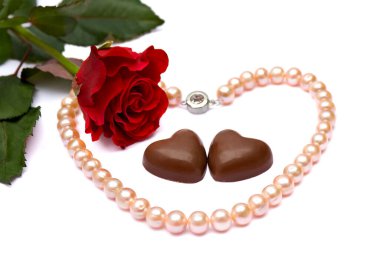 Sevgililer Günü kompozisyonu kırmızı gül, çikolatalı şeker ve inci kolye beyaz arka planda metin için boşluk