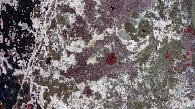 ... siyah, gri ve kırmızı eski püskü boya lekeleri olan kirli taş duvar arka planı.