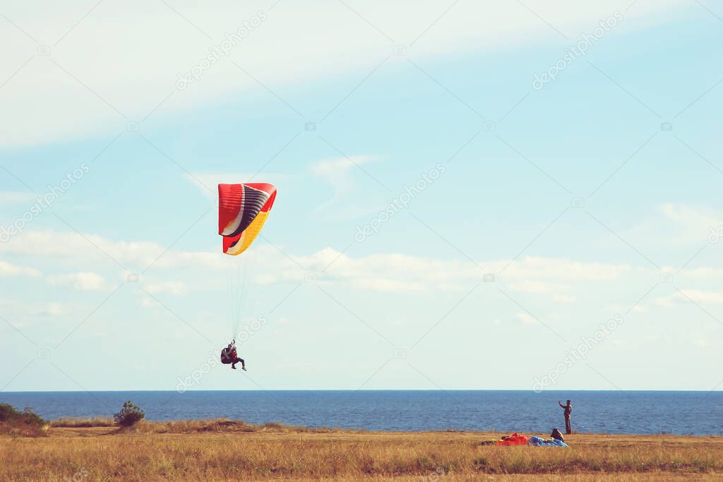 paragliders training by the sea shore in autumn