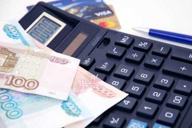Ruble banknotlar, hesap makinesi, kalem ve bulanık kredi kartları