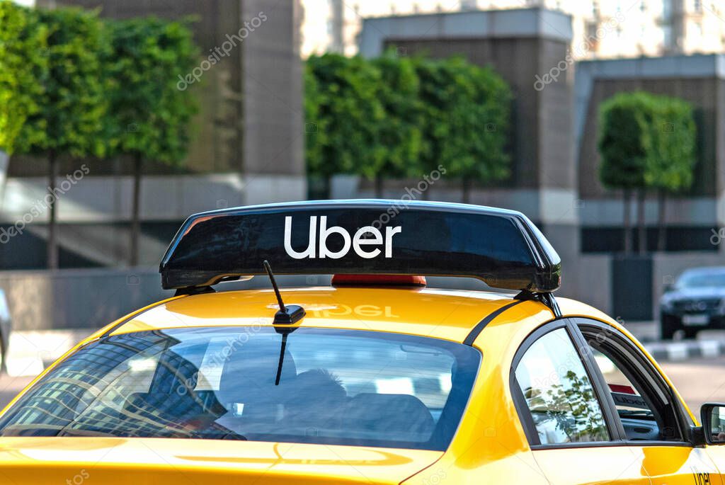 Yellow taxi cab on the street with Uber logo icon on top - Moscow, 09//09/2020