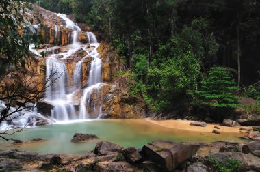 Sungai Pandan Su Düşüşü Sahnesi. Sungai Pandan Şelalesi Felda Panching Selatan Pahang 'daki Kuantan kasabasına 25 km uzaklıkta. Yumuşak su akışıyla yavaş bir deklanşör resmi.