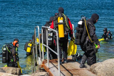 Malmö, İsveç - 14 Haziran 2020: Scuba dalgıçları okyanusta dalmak için suya girerler