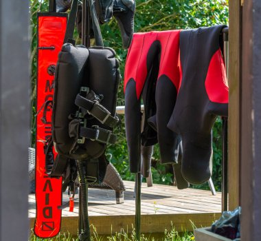 Tüplü dalış ekipmanları dalıştan sonra bir bahçede kurumak için asılı duruyor. Fotoğraf: İskandinav, Güney İsveç