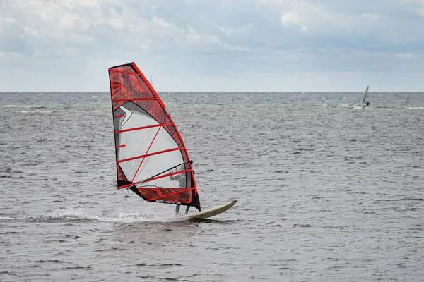 On a windy day many people take the opportunity to do watersports. Windsurfers gather near Lomma beach to practice their windsurfing skills — Stock Photo, Image