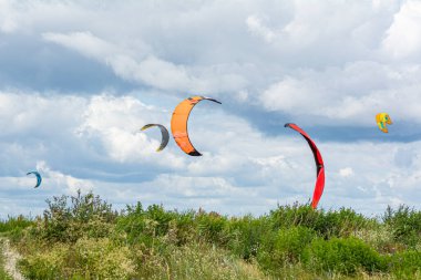 Rüzgarlı bir günde birçok insan su sporları yapma fırsatını kullanır. Uçurtmacılar uçurtma sörfü becerilerini geliştirmek için Lomma plajında toplandılar.