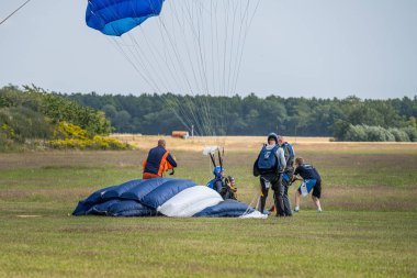 Tatil boyunca güzel bir gün. Pek çok kişi en sevdiği sporu yapıyor. Hava dalışı sonrası paraşütçünün inişi.