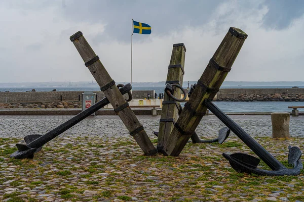 스웨덴 헬싱보리에 있는 파라 페텐에는 세 개의 오래 된 닻이 있습니다. 닻은 해상 활동과의 길고도 친밀 한 관계를 나타낸다. 뒤에 있는 스웨덴 국기 — 스톡 사진