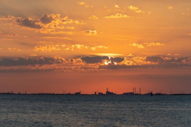 Güzel bir yaz akşamı okyanusun üzerinde çarpıcı turuncu bir gün batımı. Fotoğraf: Öresund, Malmö, İsveç