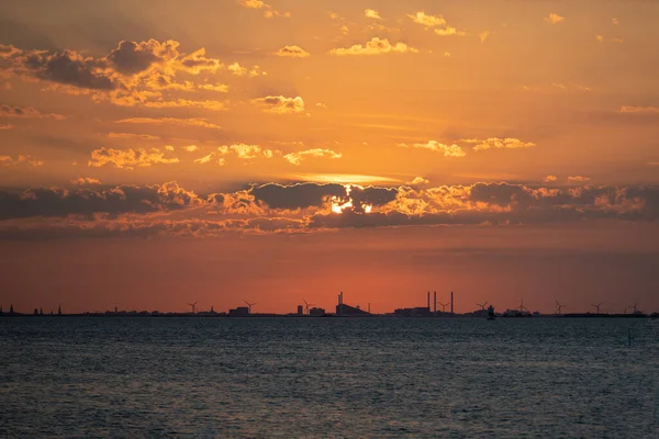 Una impresionante puesta de sol naranja sobre el océano una hermosa noche de verano. Foto de Oresund, Malmo, Suecia — Foto de Stock