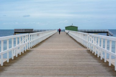 Arka planda mavi okyanus ve gökyüzü olan ahşap bir iskele. Fotoğraf: Malmö, İsveç