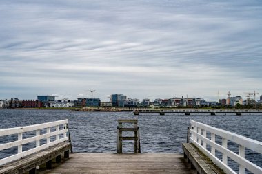Arka planda mavi okyanus ve gökyüzü olan ahşap bir iskele. Fotoğraf: Malmö, İsveç