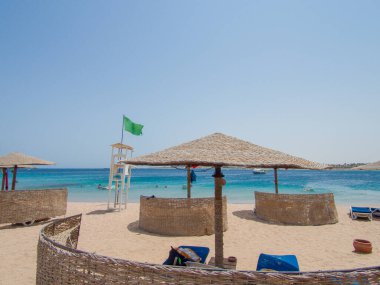 A picture of the beach in a luxury resort in Hurghada, by the the Red Sea, Egypt. Blue sky and ocean in the background