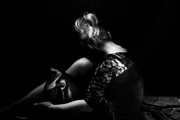 一个优雅的女人坐在黑暗中的画像 黑白演播室拍摄 — 图库照片