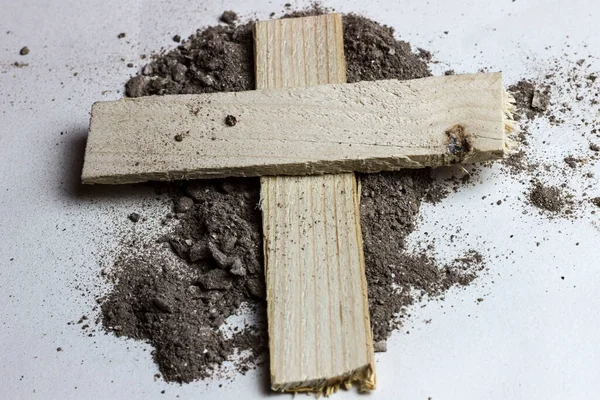Cross shape made of wood and ashes. Ash Wednesday, Lent. Christian religion.