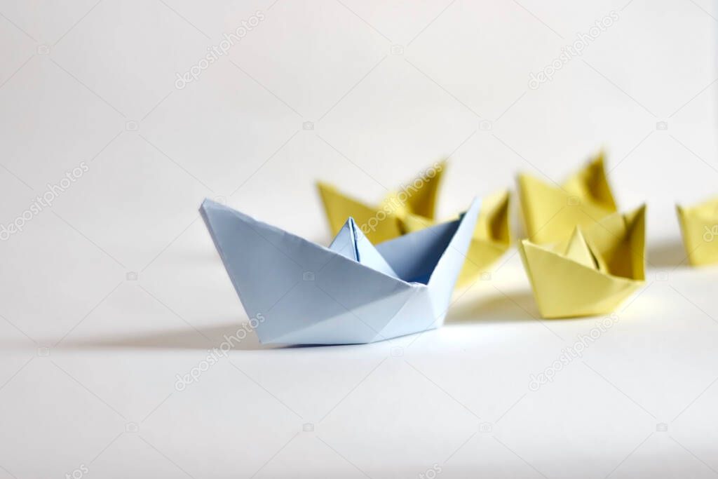 Leadership concept. Paper boats on white background.