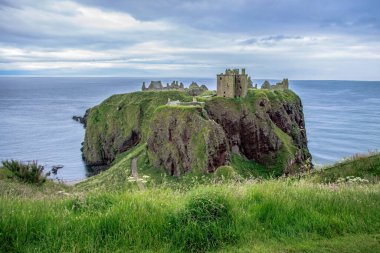 Dunnottar Şatosu. Stonehaven 'ın yaklaşık 2 mil güneyinde, İskoçya' nın kuzeydoğu kıyısındaki kayalık bir burnun üzerinde yıkık bir ortaçağ kalesi. Aberdeenshire, İskoçya, İngiltere.