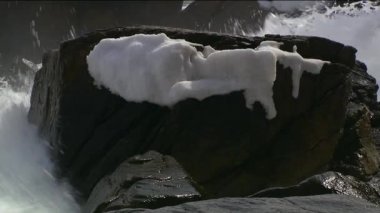 Deniz sörfü. Deniz dalgası taşlara çarpıyor. Binlerce deniz dalgası sıçrıyor. Güçlü fırtına