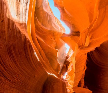 Güneş ışığı bacaları, Arizona 'daki Antilop Kanyonu' nun duvarlarına parlak lekeler çizer.
