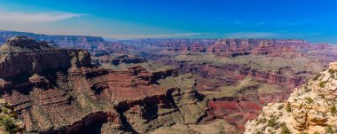 Büyük Kanyon 'un renkli kaya katmanlarını gösteren bir panorama kuzey kenarı, güney kenarı ve Colorado nehri kanyonunu gösteriyor.