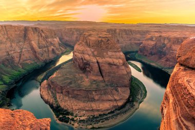 Arizona 'da, Page yakınlarında Colorado Nehri' nde Horseshoe Bend 'de günbatımı ufukta belirdi.
