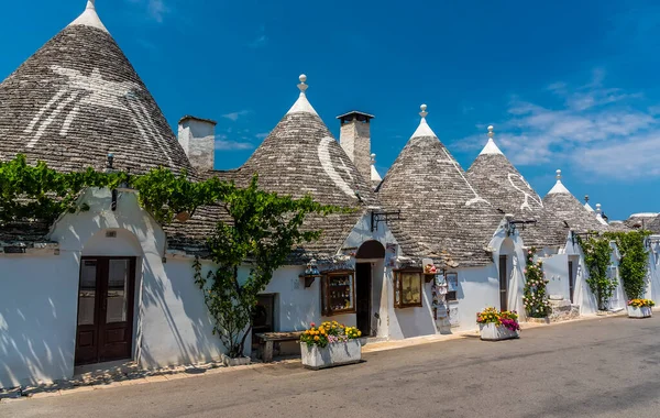 İtalya 'nın Alberobello şehrinde yaz aylarında inşa edilen geleneksel Trulli binaları sokağı.