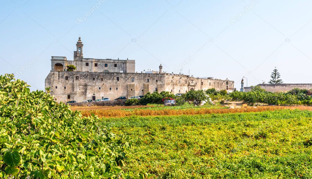 : A view across the fields towards the abbey at Cala San Vito, Puglia, Italy
