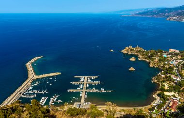 Sicilya 'nın Cefalu şehrinin yukarısındaki Mesa' daki Norman şatosunun manzarası yaz aylarında aşağıdaki yeni marina üzerinde yıkılıyor.