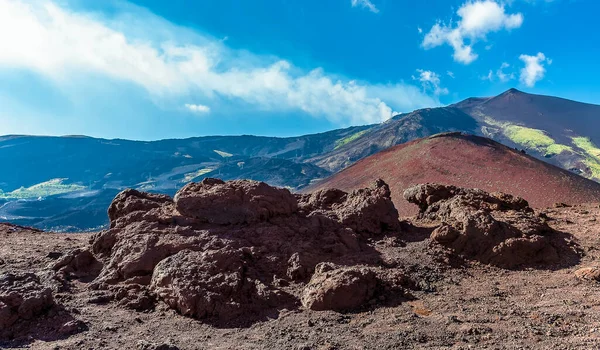 Lava rocks and secondary cones looking towards the summit of  Mount Etna, Sicily in summer