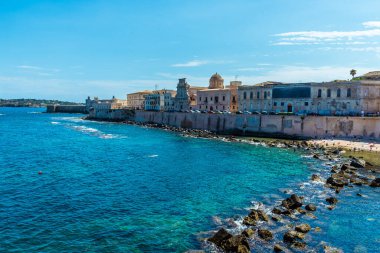 A view along the shoreline towards Castello Maniace on Ortygia island in Syracuse, Sicily in summer clipart