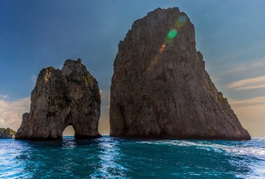 Faraglioni kayaları, İtalya 'nın Capri adasının doğu yakasında sabahın erken saatlerinde gün ışığına karşı siluet oluşturdu.